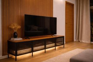 a living room with a flat screen tv on a entertainment center at Ohana Boutique Málaga Centro in Málaga