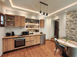 a kitchen with wooden cabinets and a table and a dining room at Meteora Gaia in Kastraki
