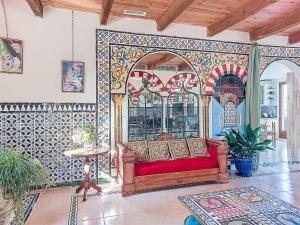 a living room with a red couch and a tile wall at Holiday Home Les Ecuries by Interhome in Alet-les-Bains
