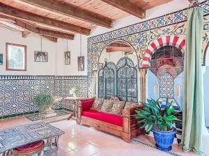 a living room with a red couch and a table at Holiday Home Les Ecuries by Interhome in Alet-les-Bains