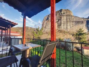a table and chairs on a balcony with a mountain at Meteora Gaia in Kastraki