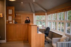 a woman talking on a cell phone in an office at Briery Wood Hotel in Ambleside
