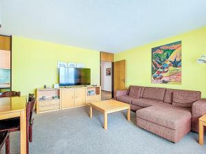a living room with a couch and a tv at Apartment Allod Park Haus C 505 by Interhome in Davos