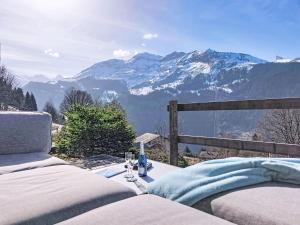 a table with wine glasses and a view of mountains at Apartment Roossi Apt- 1 by Interhome in Wengen