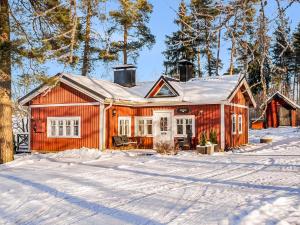 a red house in the snow with trees at Holiday Home Punatulkku by Interhome in Hirsjärvi