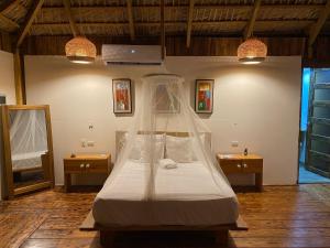 a bedroom with a bed with a mosquito net at Palmeras del valle in La Majagua