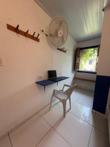 a room with a chair and a desk and a fan at Calango Hostel in Ibicoara