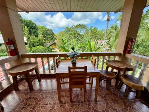 a dining room with a table and chairs and a large window at Bananaland Cottages in Panglao Island