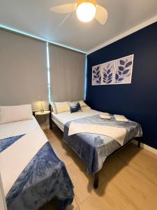 two beds in a room with blue walls at Villa Catarina in Guarulhos +7 photos
