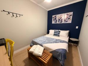 a small bedroom with a bed and a blue wall at Villa Catarina in Guarulhos
