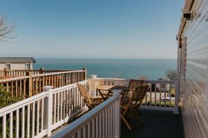 a balcony with chairs and a table and the ocean at Upper Cliff 4 in Easton