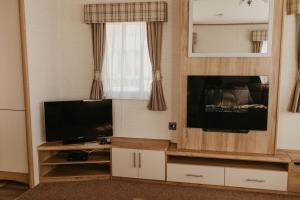 a living room with a entertainment center with a flat screen tv at Upper Cliff 4 in Easton