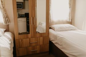 a bedroom with a dresser and a bed with a mirror at Upper Cliff 4 in Easton