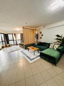 a living room with a green couch and a table at Plaza di Drama in Drama