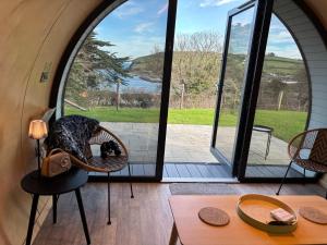 a room with a large glass door with a cat in a basket at Glenarm Castle Ocean View Pods in Glenarm