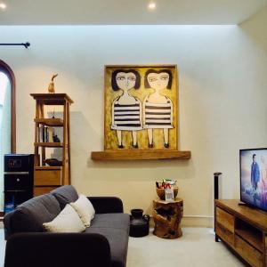 a living room with a couch and a painting on the wall at Casa Benna - Salatiga in Salatiga