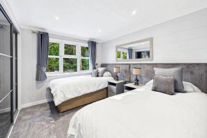 a white bedroom with two beds and a mirror at Host & Stay - Marble Lodge in Beverley +4 photos
