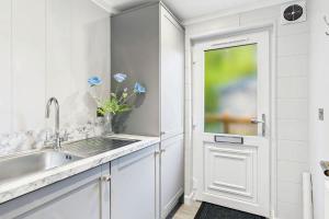 a white kitchen with a sink and a door at Host & Stay - Marble Lodge in Beverley