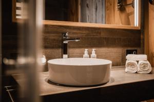 a sink in a bathroom with towels on a counter at Berghotel Kleiner Biber in Warth am Arlberg +32 photos