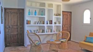a living room with two chairs and shelves with books at Villa Lucienne in Les Issambres