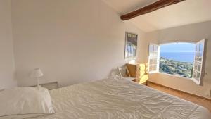a bedroom with a bed and an open window at Villa Lucienne in Les Issambres +15 photos