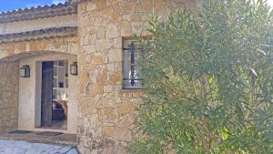 a stone house with a tree in front of it at Villa Lucienne in Les Issambres