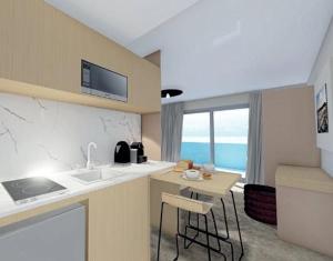 a kitchen with a sink and a counter with a table at Le VIBES RESORT By AGN "réservé aux couples" in Cap d'Agde