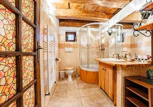 a bathroom with a tub and a toilet and a sink at Albert Authentic Suites Brasov - Tampa View - Preferred Spa Rates & Exclusive Guest Benefits in Braşov +286 photos