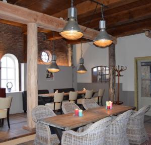 a dining room with a wooden table and chairs at De Hocht in Nes