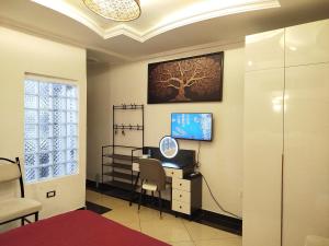 a room with a desk and a tv on a wall at Mon Nid d'Or ABIDJAN CI in Abidjan