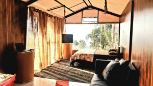 a bedroom with a bed and a large window at Kithul Cottage in Nuwara Eliya