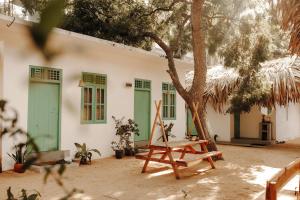 a house with green doors and a chair next to a tree at Fins Arugambay in Arugam Bay