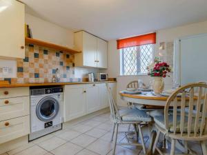 a kitchen with a table and chairs and a washing machine at 2 Bed in Ashbourne oc-82579 in Longford