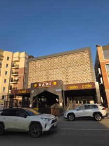 two cars parked in a parking lot in front of a bank at Dami Almaty Hotel in Almaty