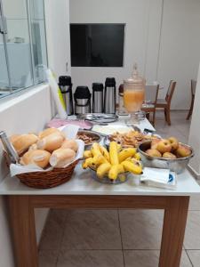 a table with a bunch of food and bananas on it at Hotel Borza Carneiro in Piraí do Sul