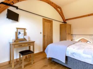 a bedroom with a bed and a desk and a television at 3 Bed in Buxton oc-52891 in Sheen