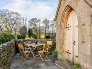 a patio with a table and chairs and a stone wall at 3 Bed in Buxton oc-52891 in Sheen