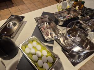 a table topped with trays of eggs and other foods at Waterloo Sunset Hotel in Erzhausen