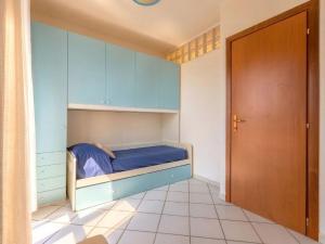 a small bedroom with a bed with blue cabinets at Apartment Rais 13 by Interhome in Stintino