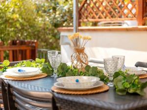 a black table with plates and flowers on it at Apartment Rais 13 by Interhome in Stintino +28 photos