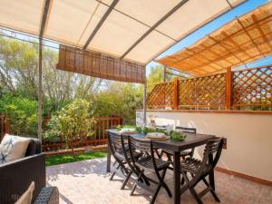 an outdoor dining room with a table and chairs at Apartment Rais 13 by Interhome in Stintino
