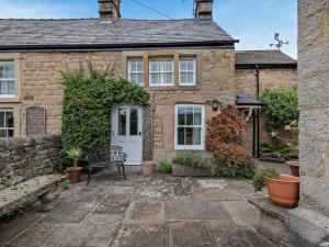 a stone cottage with a bench in front of it at 2 Bed in Bakewell oc-61862 in Baslow
