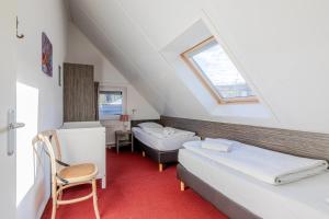 a attic room with two beds and a window at Landal Winterberg in Winterberg