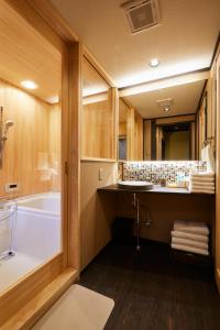 La salle de bains est pourvue d'une baignoire et d'un lavabo. dans l'établissement Miro Hachijo Uchidacho Tei, à Kyoto