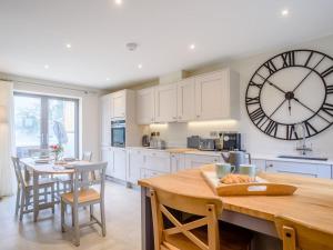 a kitchen with a large clock on the wall at 2 Bed in Chipping Campden oc-78128 in Chipping Campden