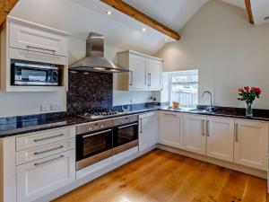 a kitchen with white cabinets and black counter tops at 3 Bed in Eyam oc-pk835 in Eyam
