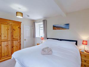 a bedroom with a white bed with a towel on it at 3 Bed in Eyam oc-pk835 in Eyam