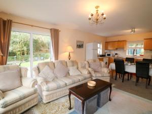 a living room with a couch and a table at Lugdine Lodge in Glengarriff