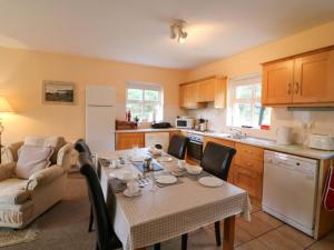 a kitchen with a table and a kitchen with a table and chairs at Lugdine Lodge in Glengarriff +24 photos