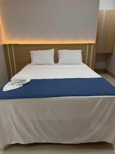 a bed in a room with a blue and white mattress at Hotel Marinho in Gurupi